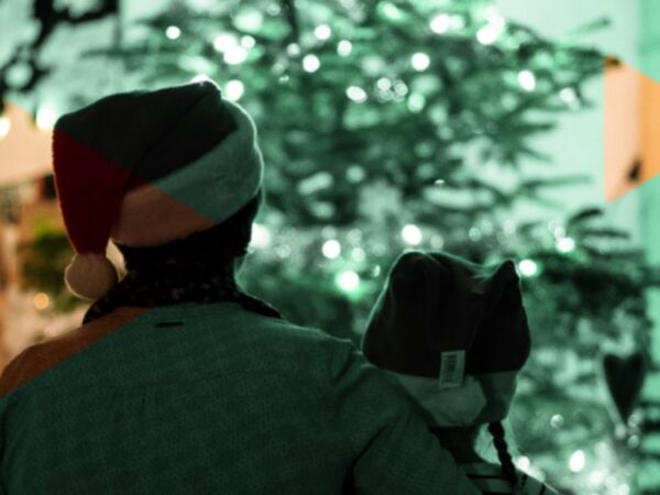 back of a person wearing a santa hat and holding a camera - collecting evergreen videos for the holidays