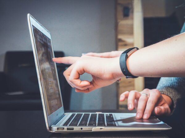 hands pointing at computer screen