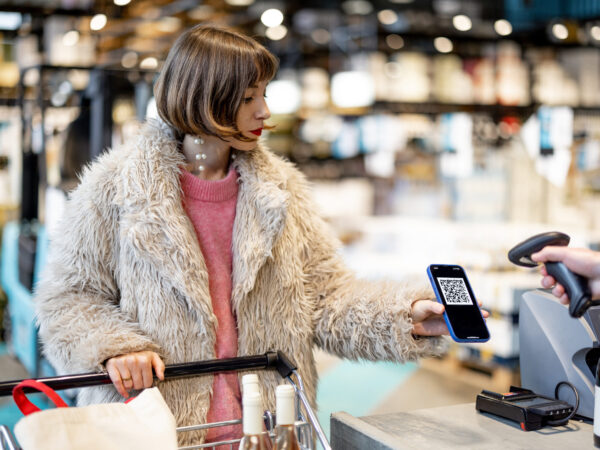 woman scans her loyalty card at checkout